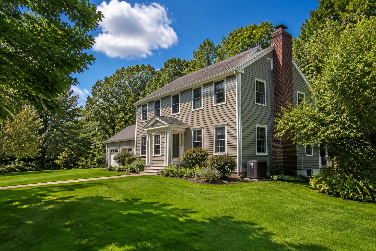 A welcoming Waterbury colonial on a bright summer day under a wide valley sky